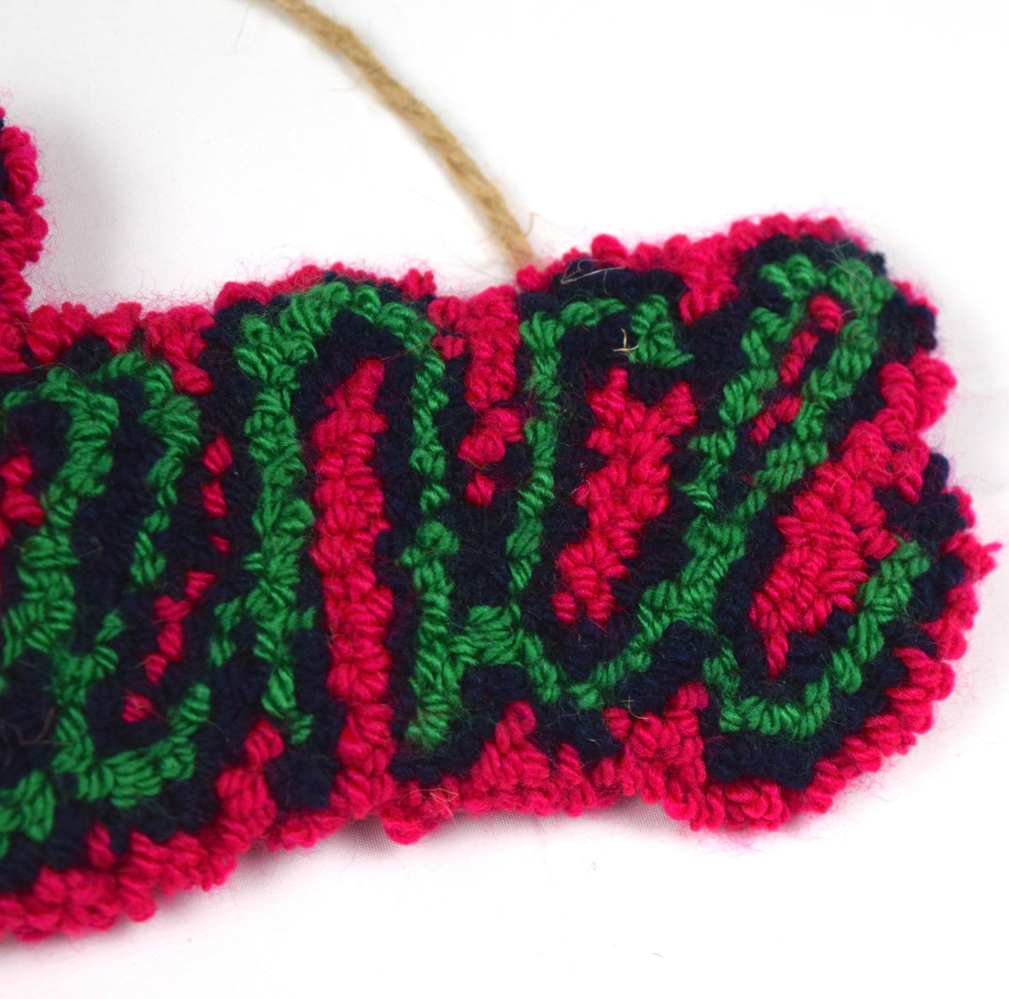 A flowing hand punched DANCE in a slanted shadow text in Neon Pink, Navy and Green using yarn from a previous project close up.