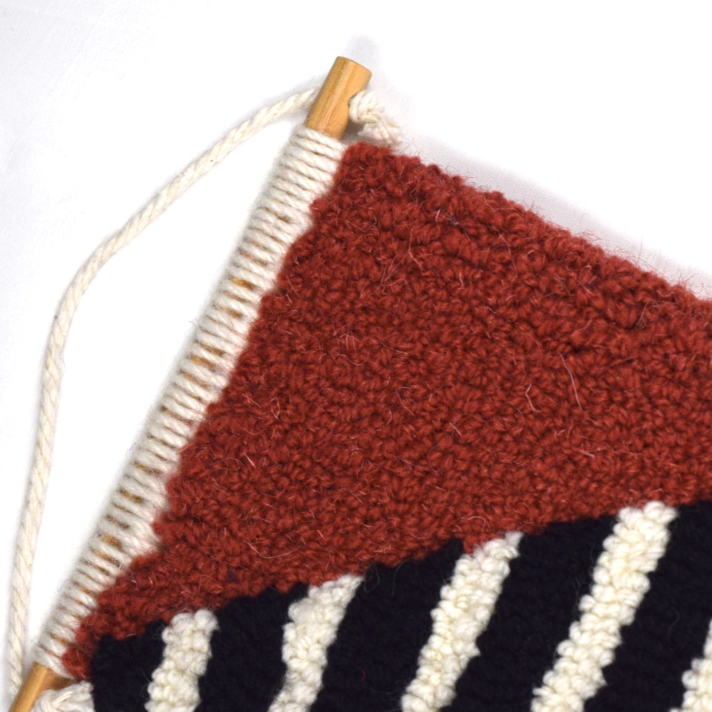 Wall Hanging using British Wool and Reclaimed Yarns.  A mixture of loop and cut piles.  Using Coral, Yellow, Khaki and Green Block Colours and a Black and White striped pattern to create and contemporary design close up.