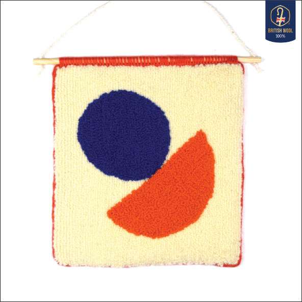 A contemporary hand punched wall hanging, using a simple semi circle with a circle balanced on top of it. Colourful, showcasing the beauty of simplicity, created using Royal Blue, Cream, Coral and Orange British Wool with a hand bound Coral edge. 