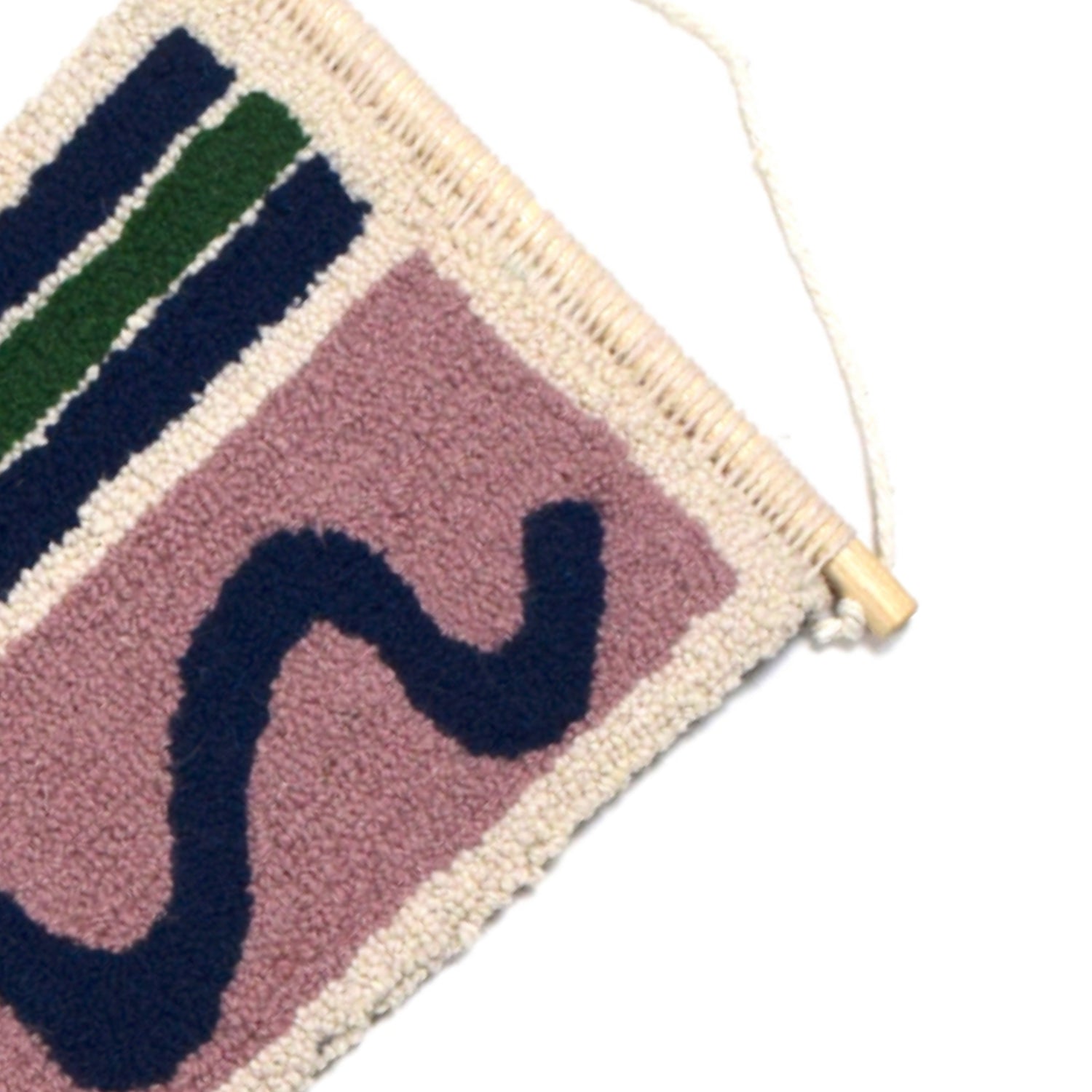 A loop pile tufted wall hanging using doodled shapes, squiggles, rectangles, stripes, triangles and patterns using reclaimed yarns. Lilac, Navy, Cream, Royal Blue and Green close up.