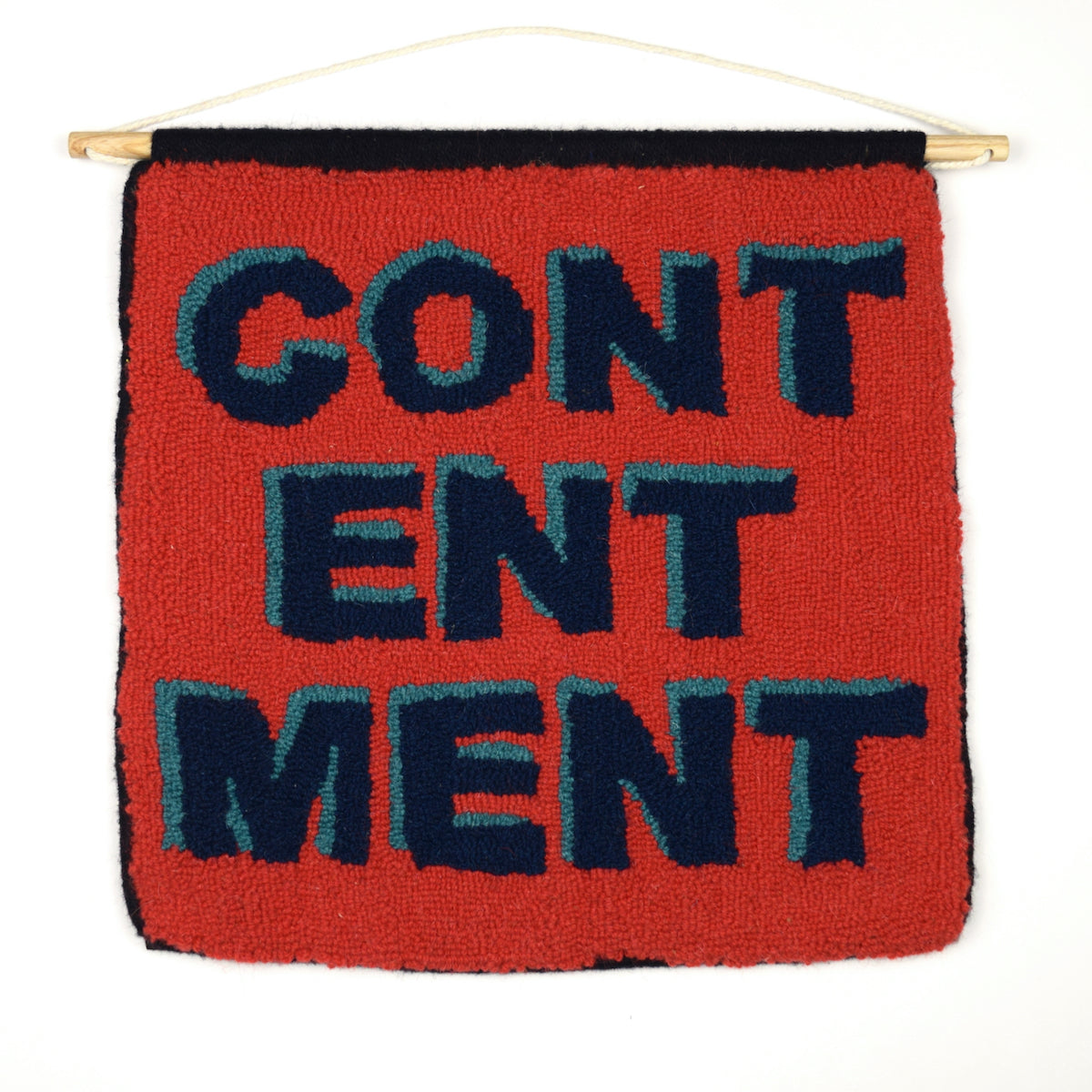 Loop pile Wall Hanging with the word CONTENTMENT in 3D typography. Made using reclaimed yarn, with a red background, turquoise shadows, navy lettering and black hand bound edges